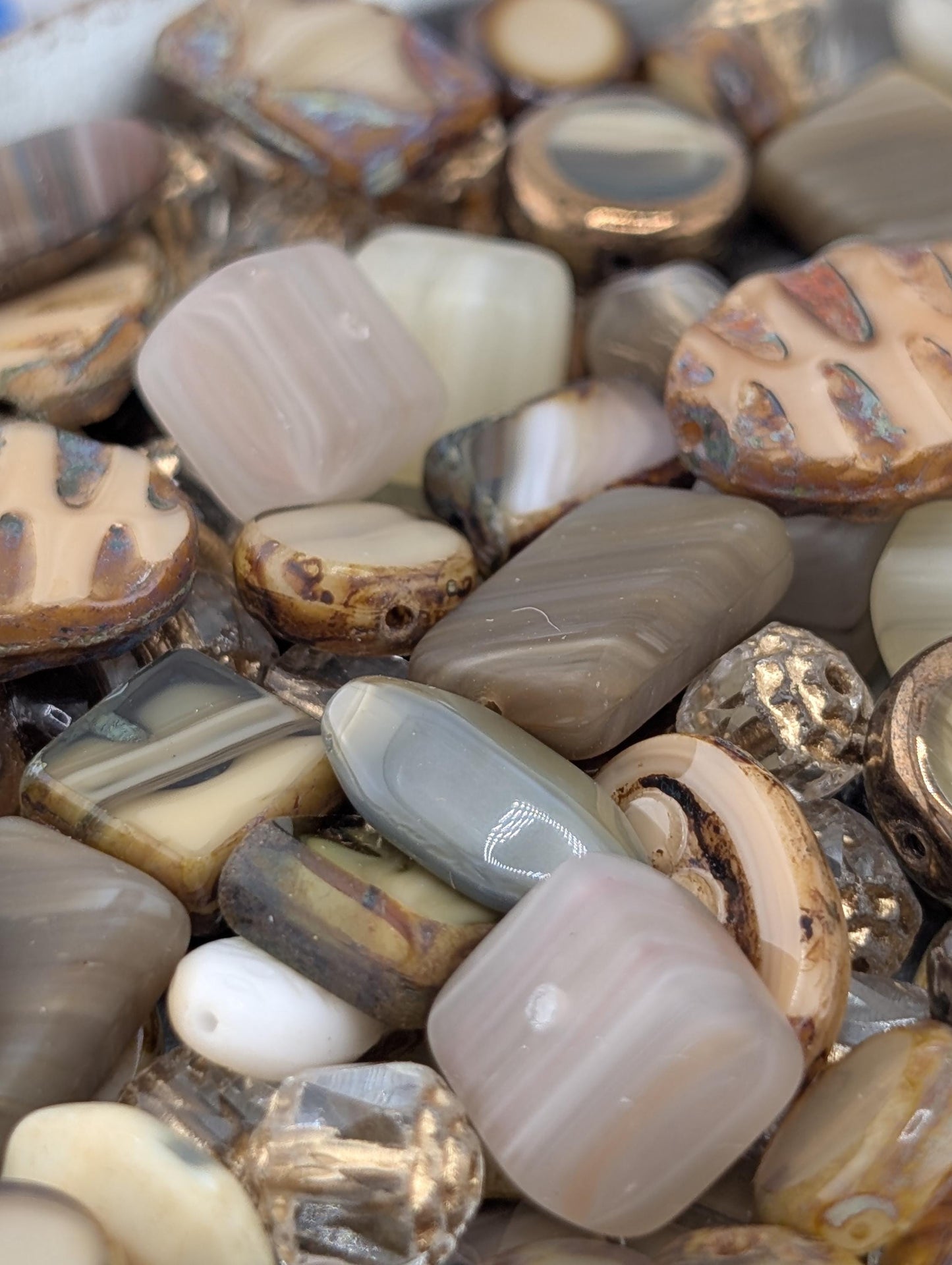 The image is a close-up of various colorful beads and stones, including amethyst, jade, and other natural elements, arranged in a visually appealing manner.
