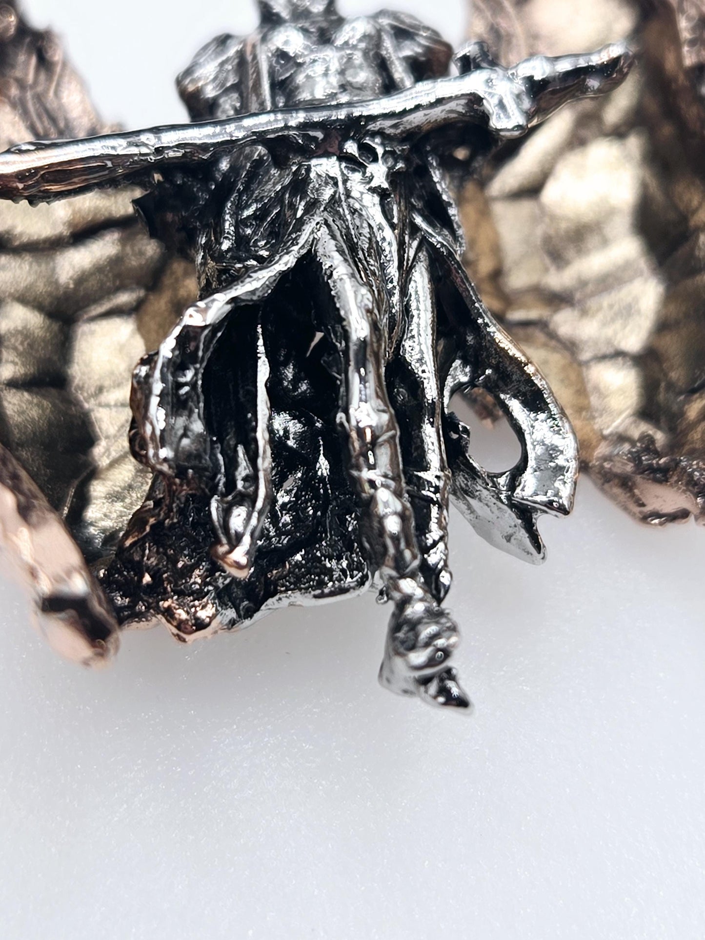 a close-up view of a metallic sculpture with a textured, organic shape.