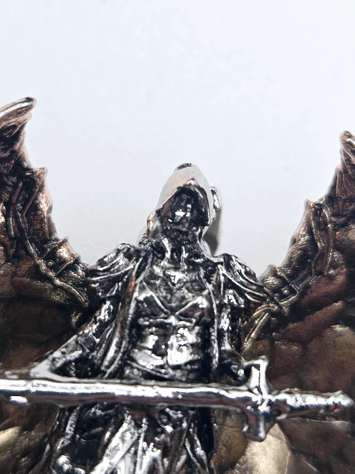 A close-up view of a metallic, sculpted object with a textured, metallic surface.