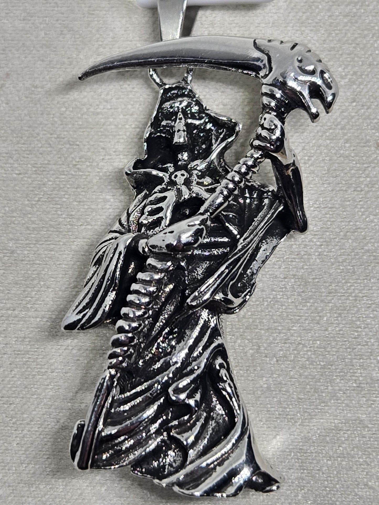 A silver brooch or pin featuring a detailed, intricate design of a skull and crossbones symbol.