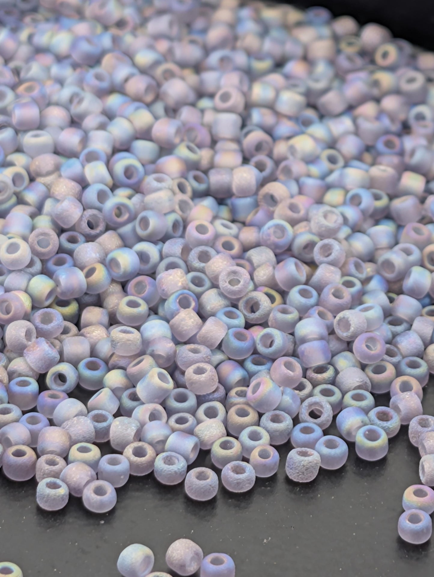 A pile of multicolored glass beads on a dark surface.