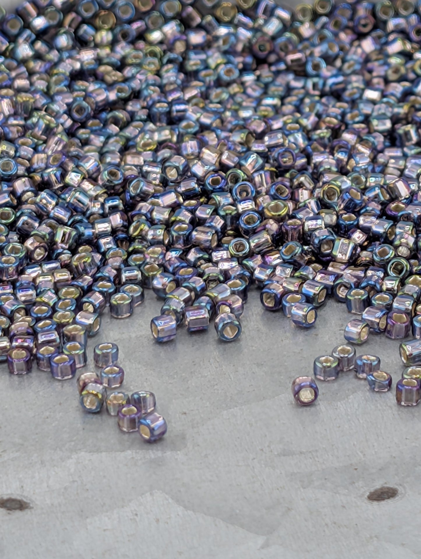 a large pile of multicolored beads scattered on a surface, with some of the beads falling off the edge.