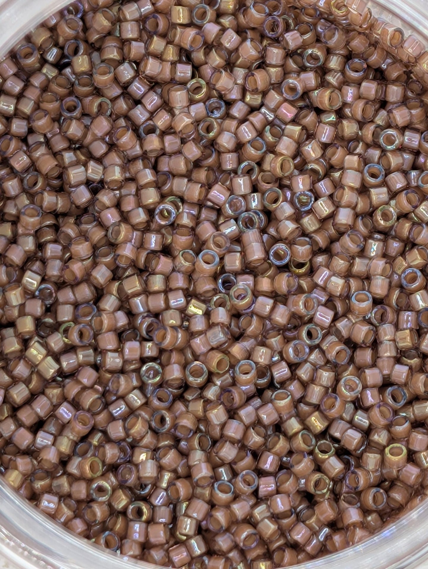 A close-up image of a large pile of brown beads or beads, possibly made of glass or plastic, arranged in a container.
