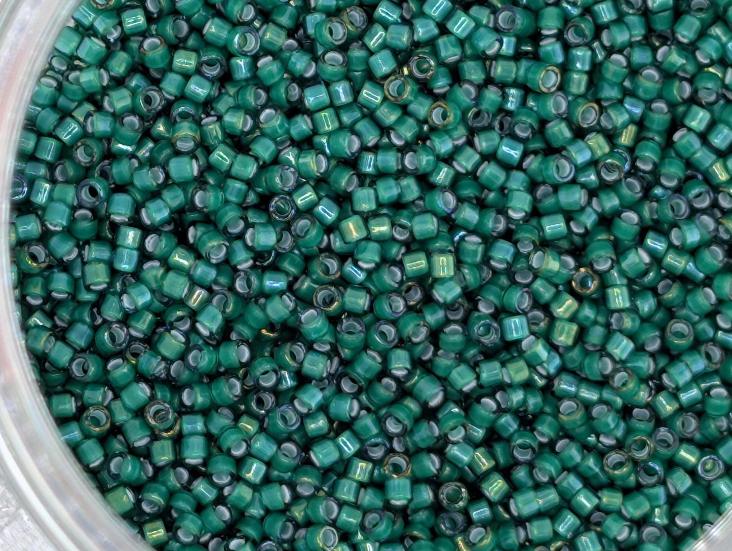 A close-up image of a large pile of green glass beads or beads, with a variety of sizes and shapes.