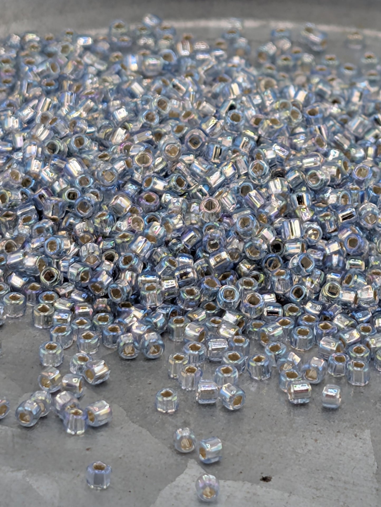 a large pile of small, clear beads scattered on a surface.