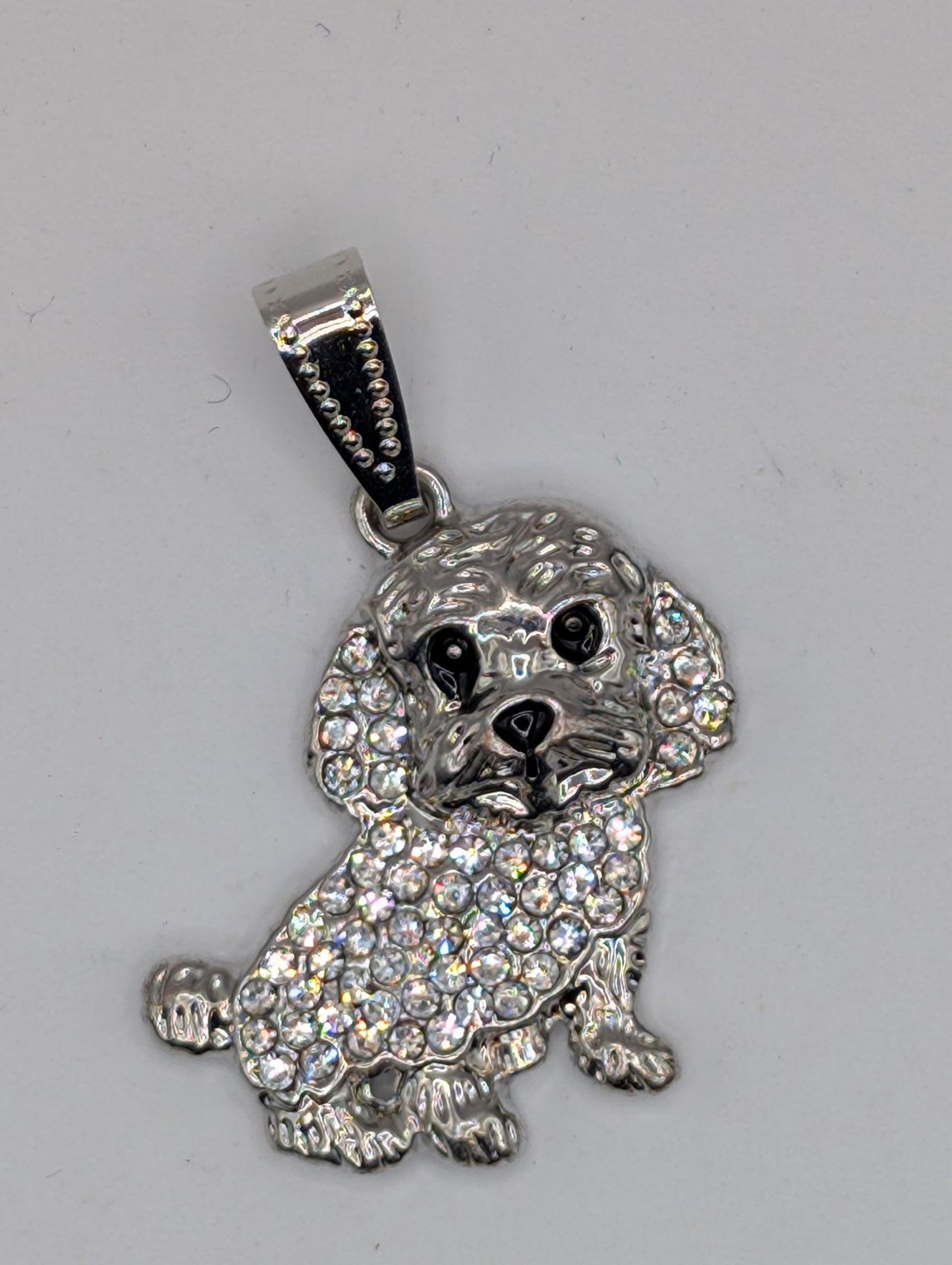 A silver-colored poodle charm with a sparkling crystal design.