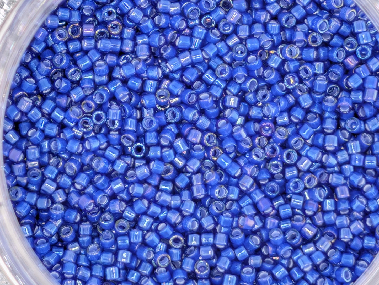 A close-up image of a container filled with numerous small blue beads.