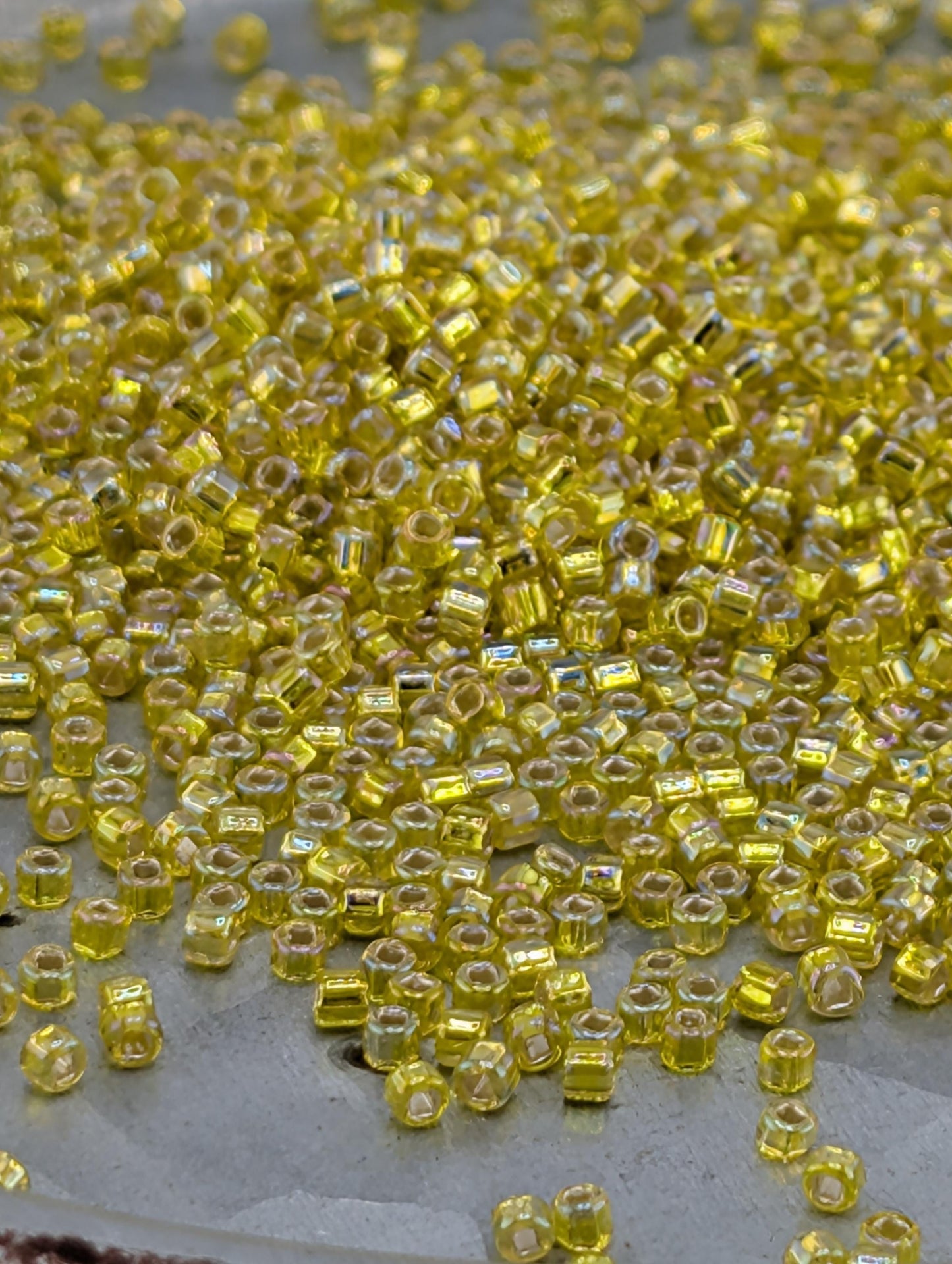 a close-up view of numerous small, yellow beads scattered across a surface.