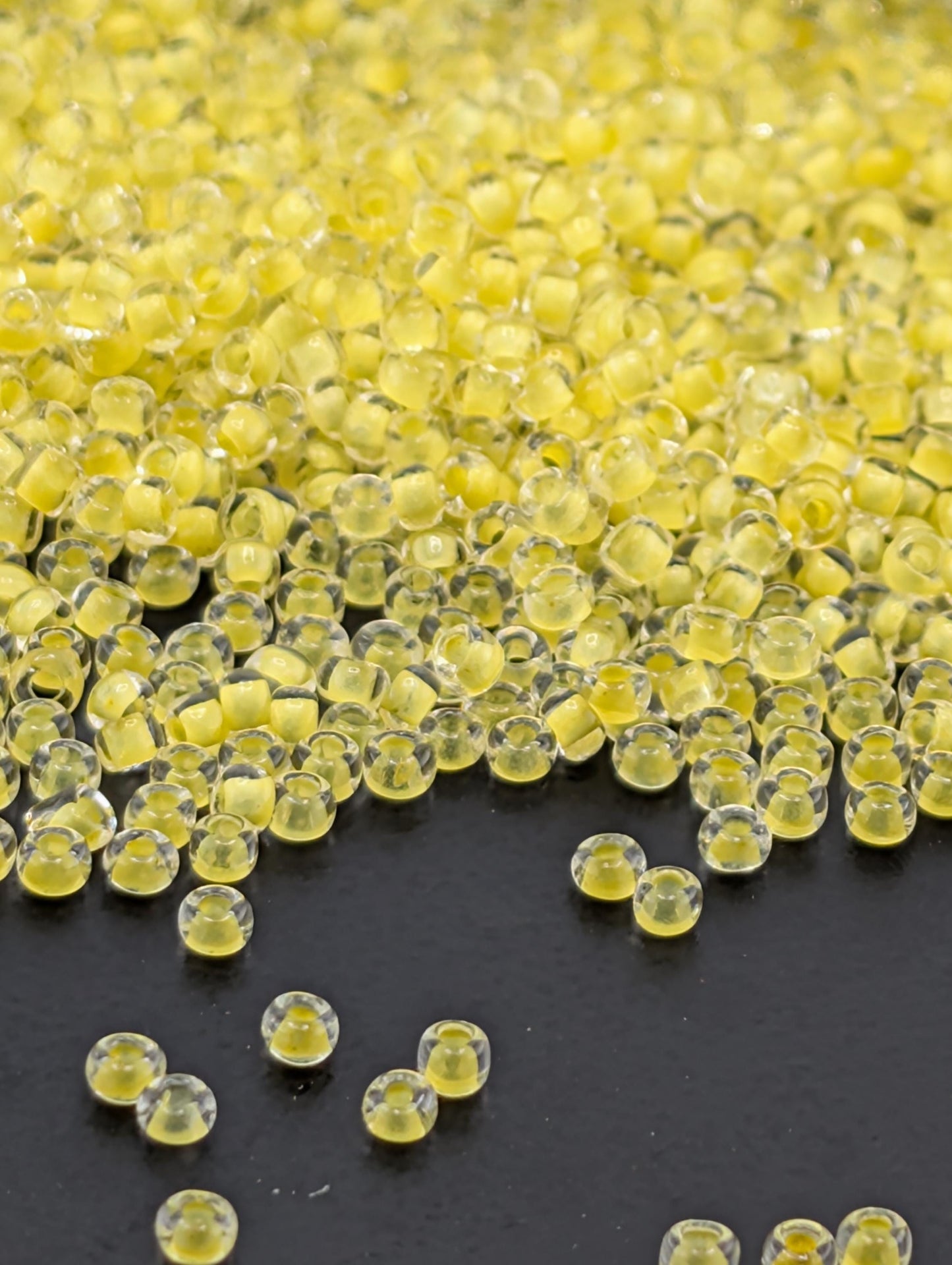 a close-up view of numerous small, clear beads scattered across a dark surface.