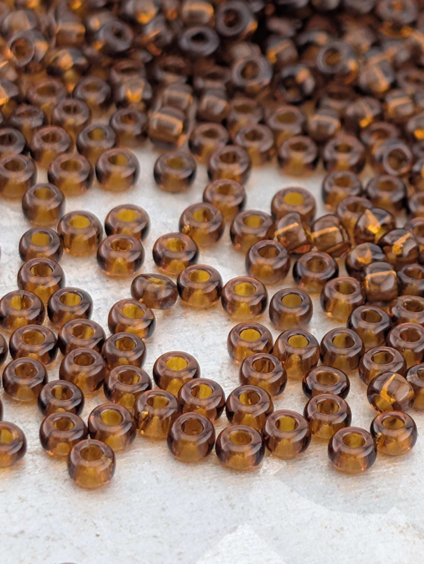 a collection of brown glass beads scattered on a white surface.
