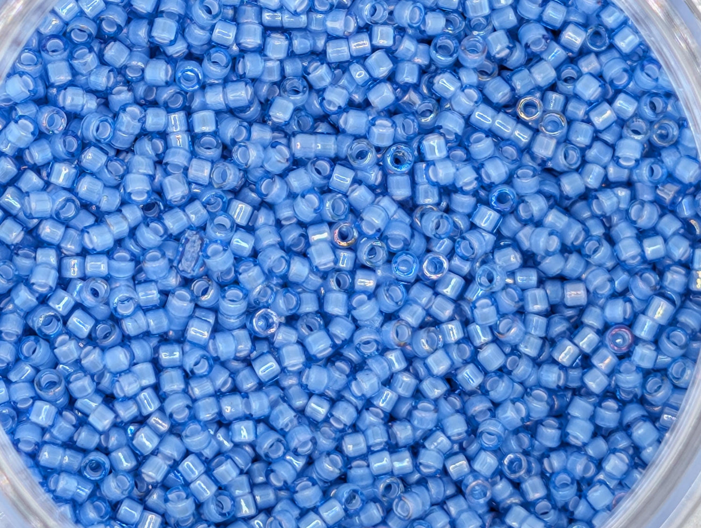A close-up image of a container filled with numerous small blue beads.