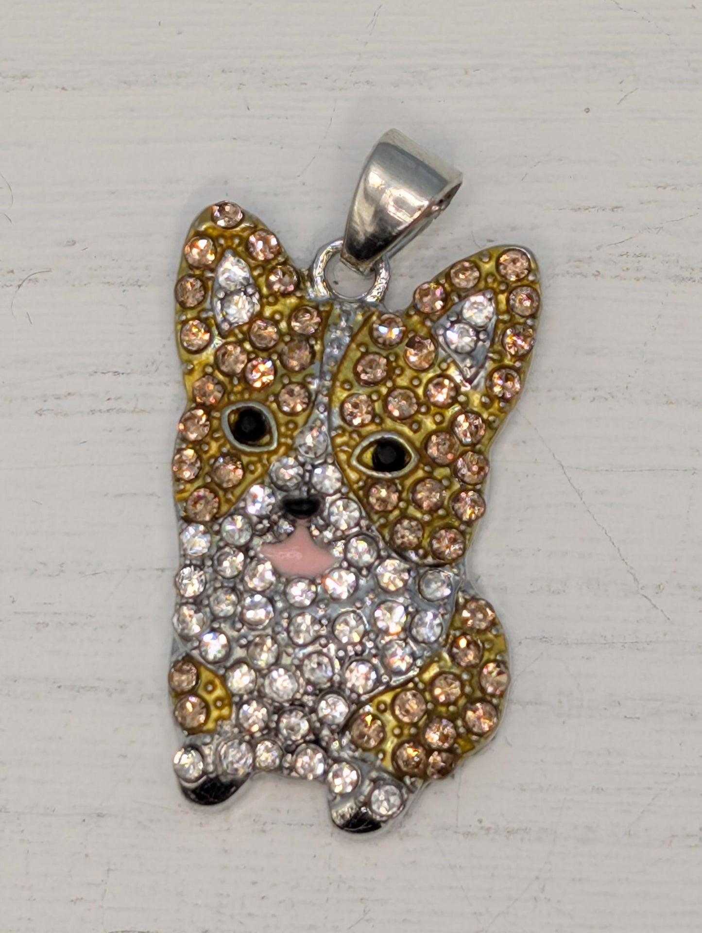 A pendant in the shape of a dog, adorned with numerous sparkling rhinestones in various colors.