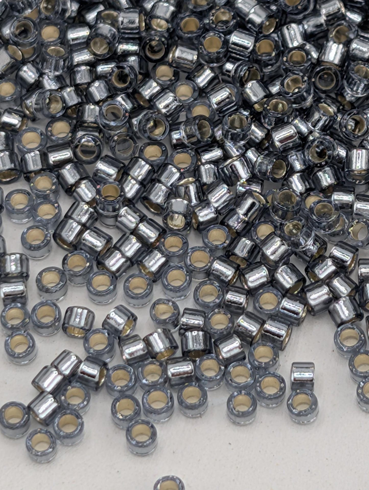 numerous small, silver-colored beads or metal pieces scattered across a surface.