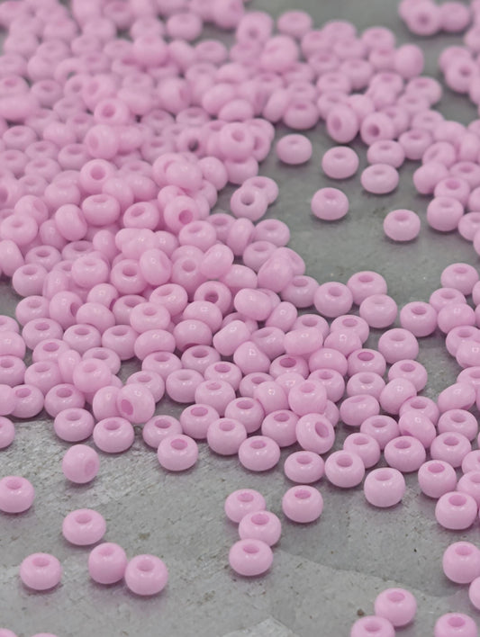 a close-up view of numerous small, round, pink beads scattered across a surface.