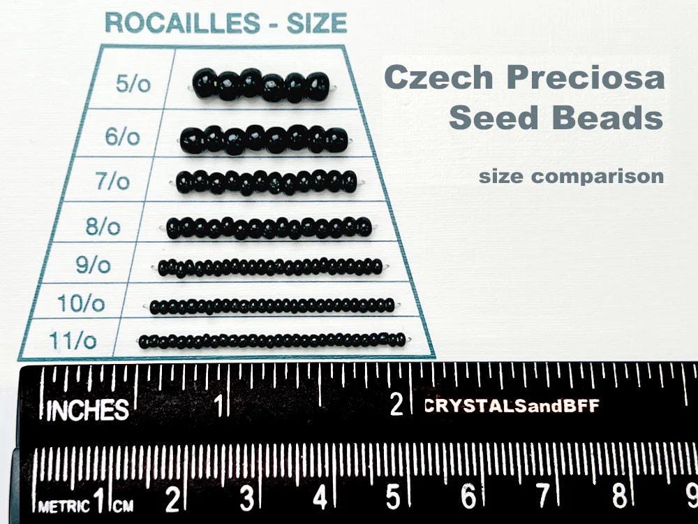 a collection of black beads in various sizes, ranging from 5/0 to 11/0, arranged on a table with a ruler for size comparison.