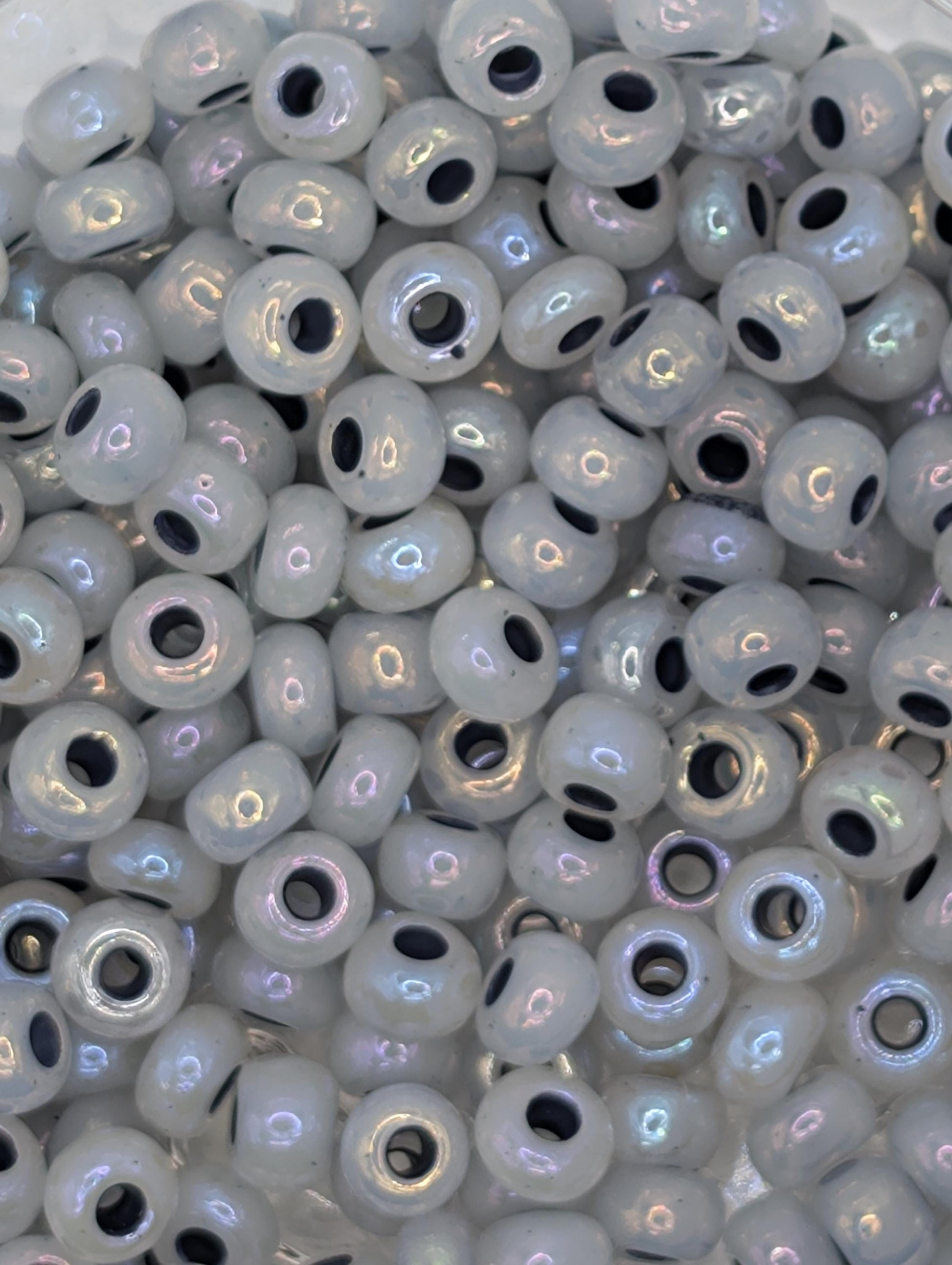 numerous small, round beads with a white and black color scheme. The beads are scattered throughout the frame, creating a visually interesting and textured composition.