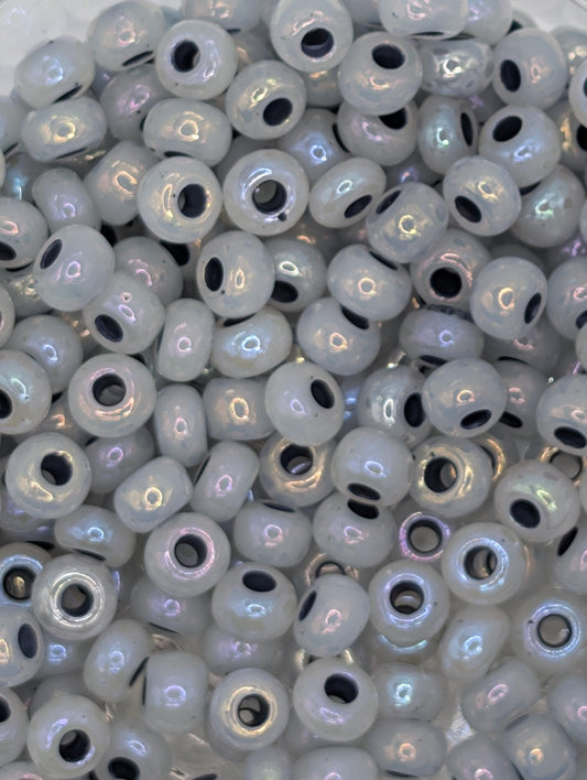 numerous small, round beads with a white and black color scheme. The beads are scattered throughout the frame, creating a visually interesting and textured composition.