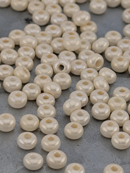 a collection of small, white beads scattered on a gray surface.