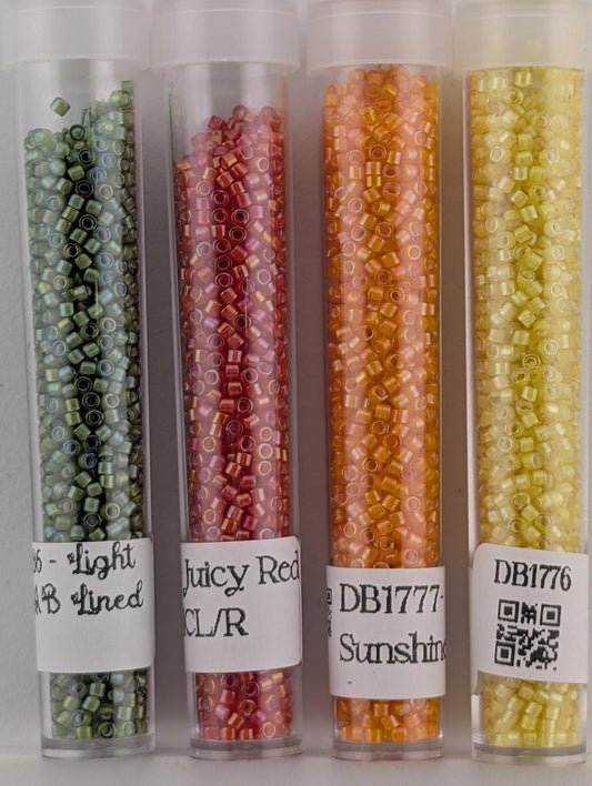 four transparent glass containers filled with colorful beads, each labeled with a different color.