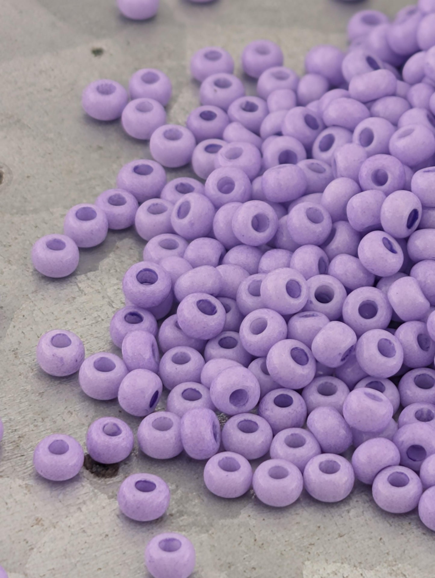 a pile of small, round, purple beads scattered on a surface.