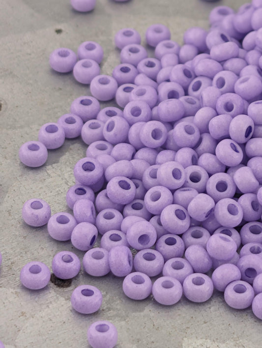 a pile of small, round, purple beads scattered on a surface.