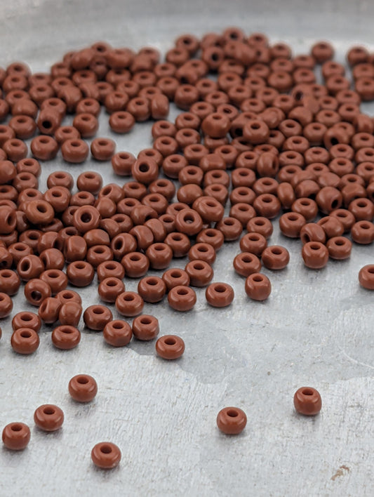 a large pile of brown beads scattered on a surface.