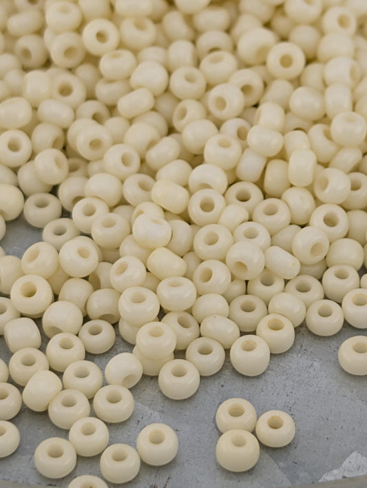 a large pile of small, white beads scattered on a surface.