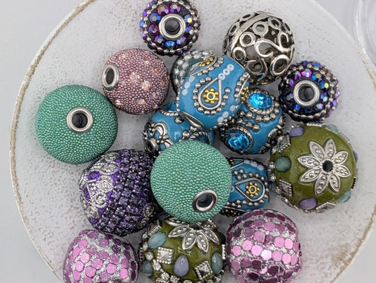 a collection of colorful beads and jewelry pieces, including various shapes and sizes, arranged on a white surface.