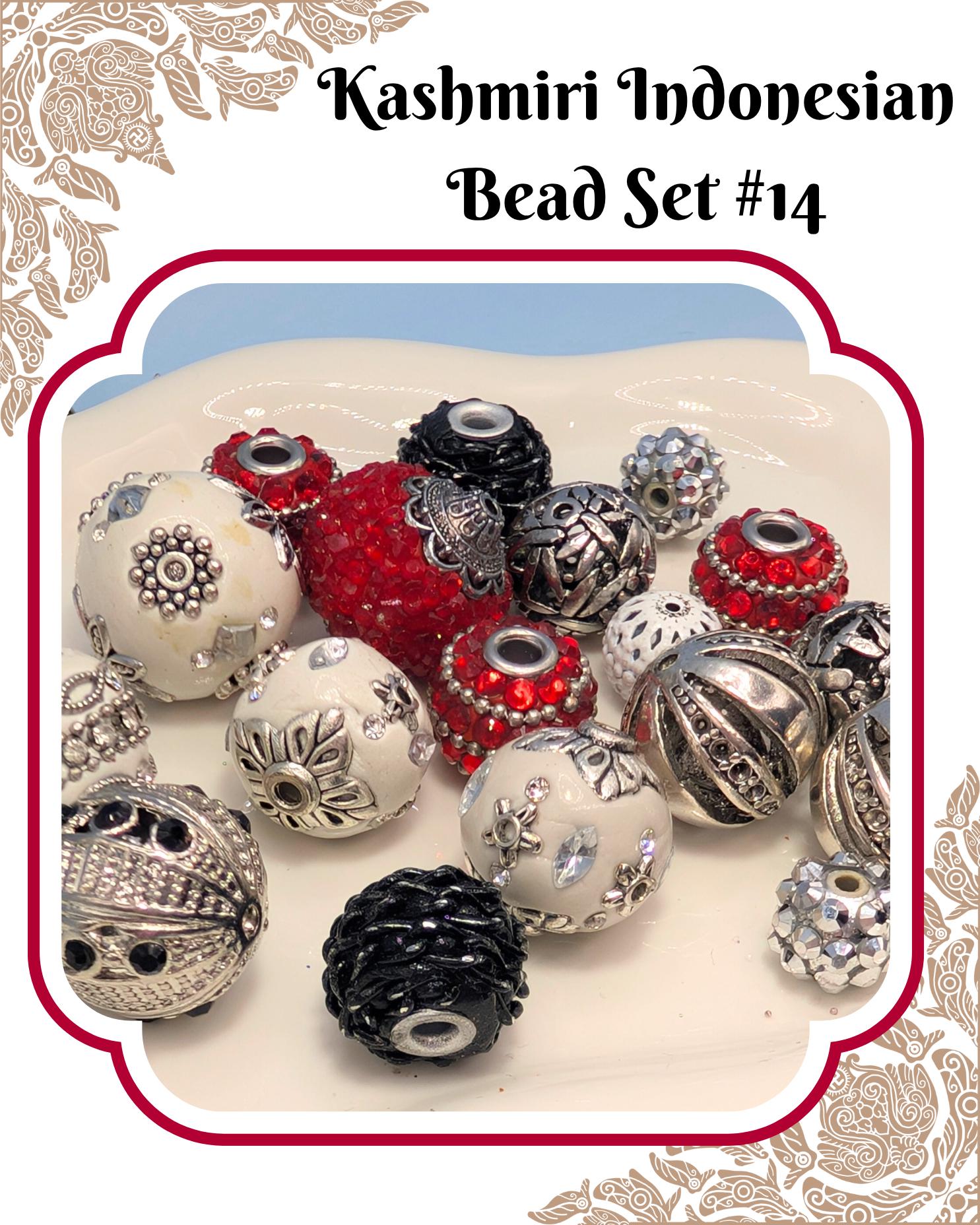 A collection of colorful beads, including red, silver, and white beads, arranged on a white surface.