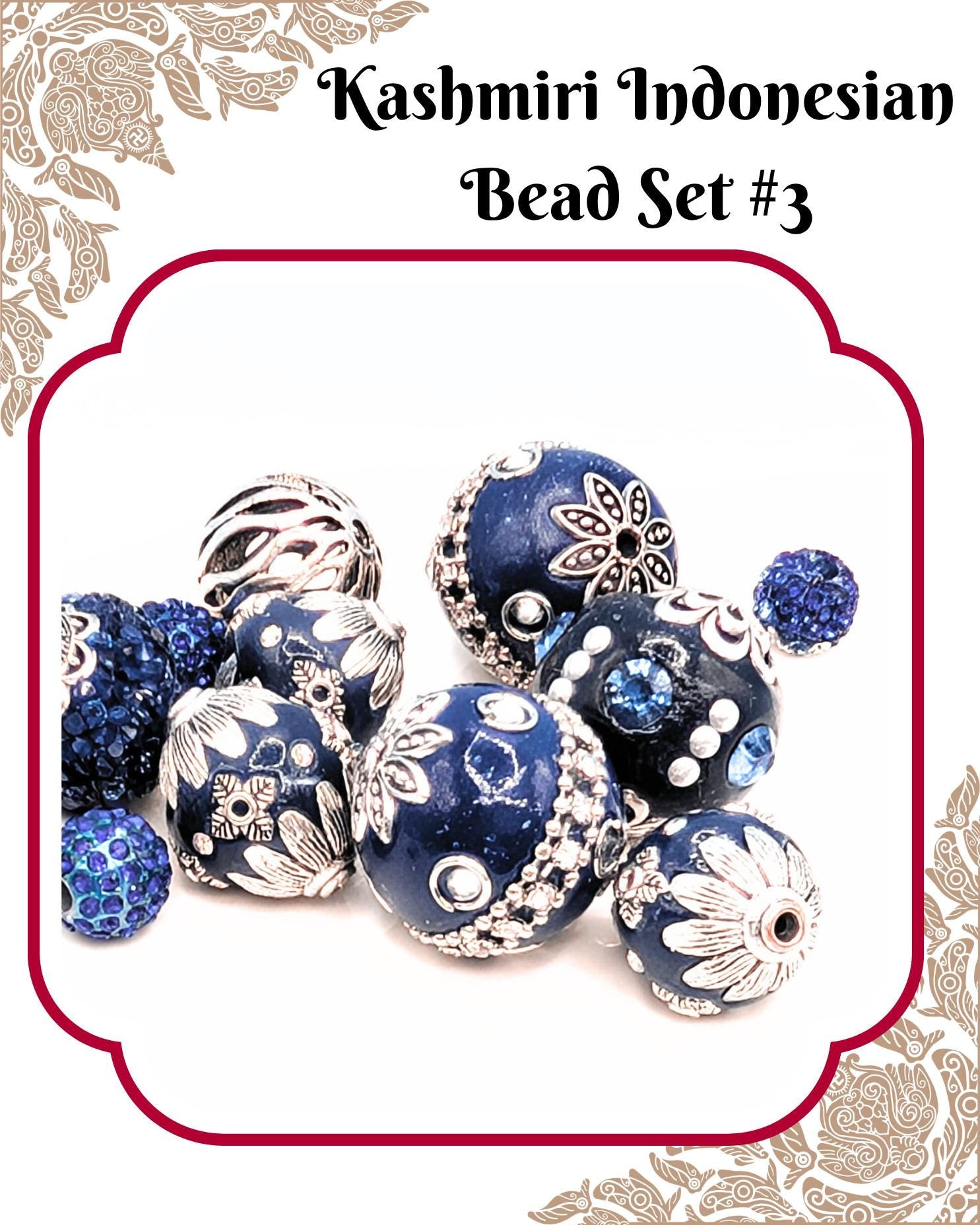 A collection of intricately designed blue and silver beads, including various shapes and patterns, arranged in a visually appealing manner.