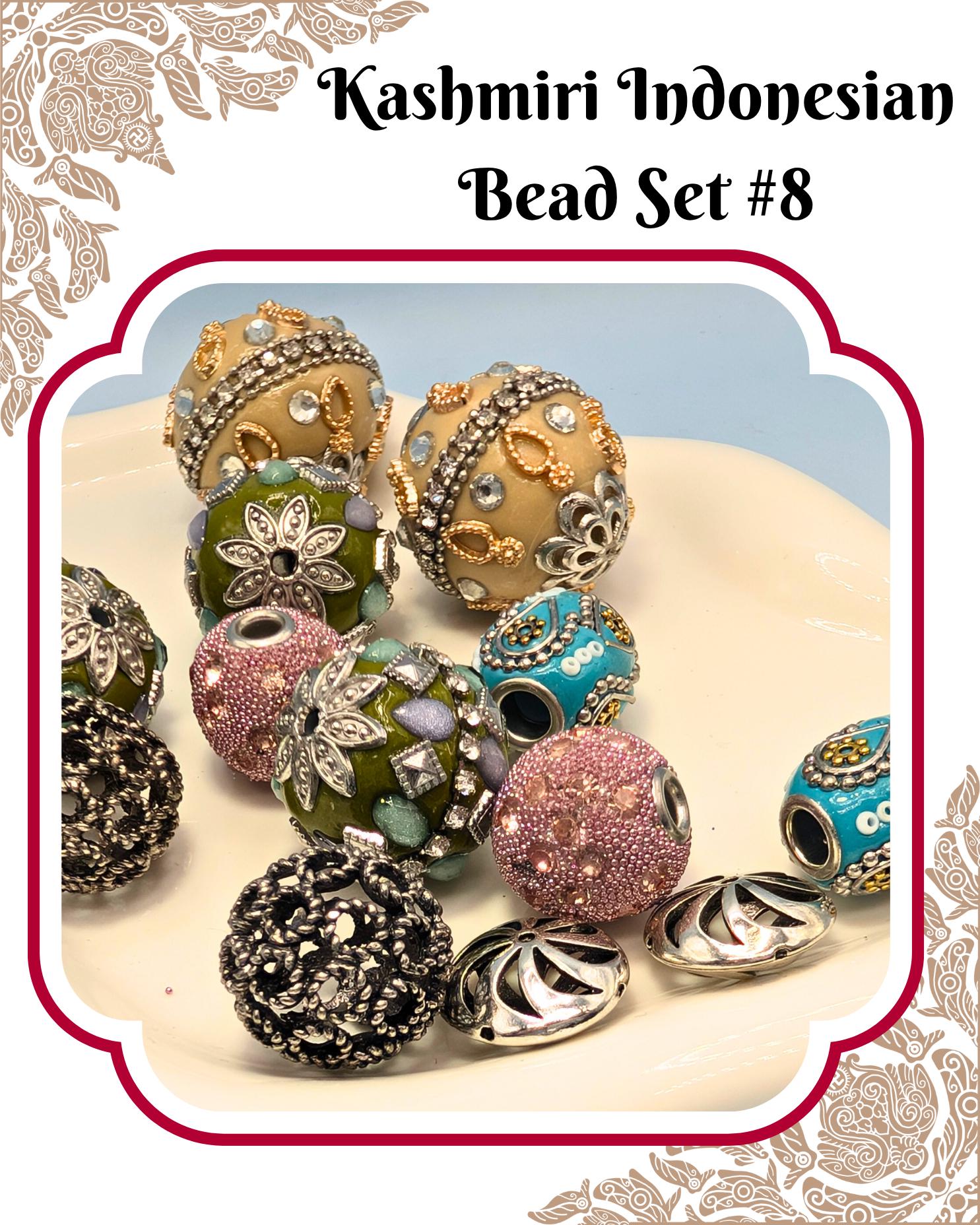 A collection of colorful, intricately designed beads in various shapes and sizes, including round, oval, and spherical beads, as well as some with metallic accents. The beads are arranged on a white surface, creating a visually appealing display.