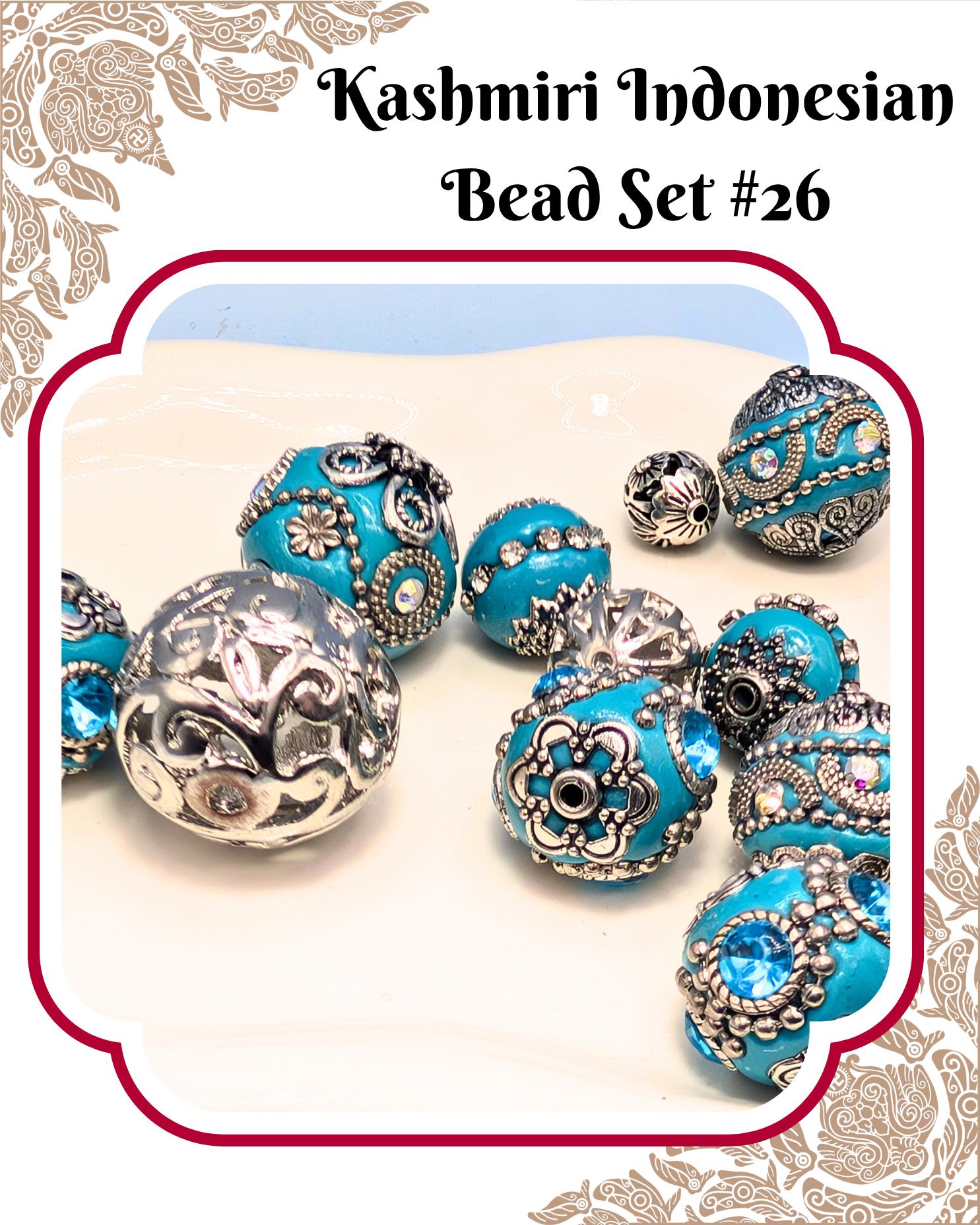 A collection of intricately designed blue and silver beads, including some with floral patterns, arranged on a white surface.