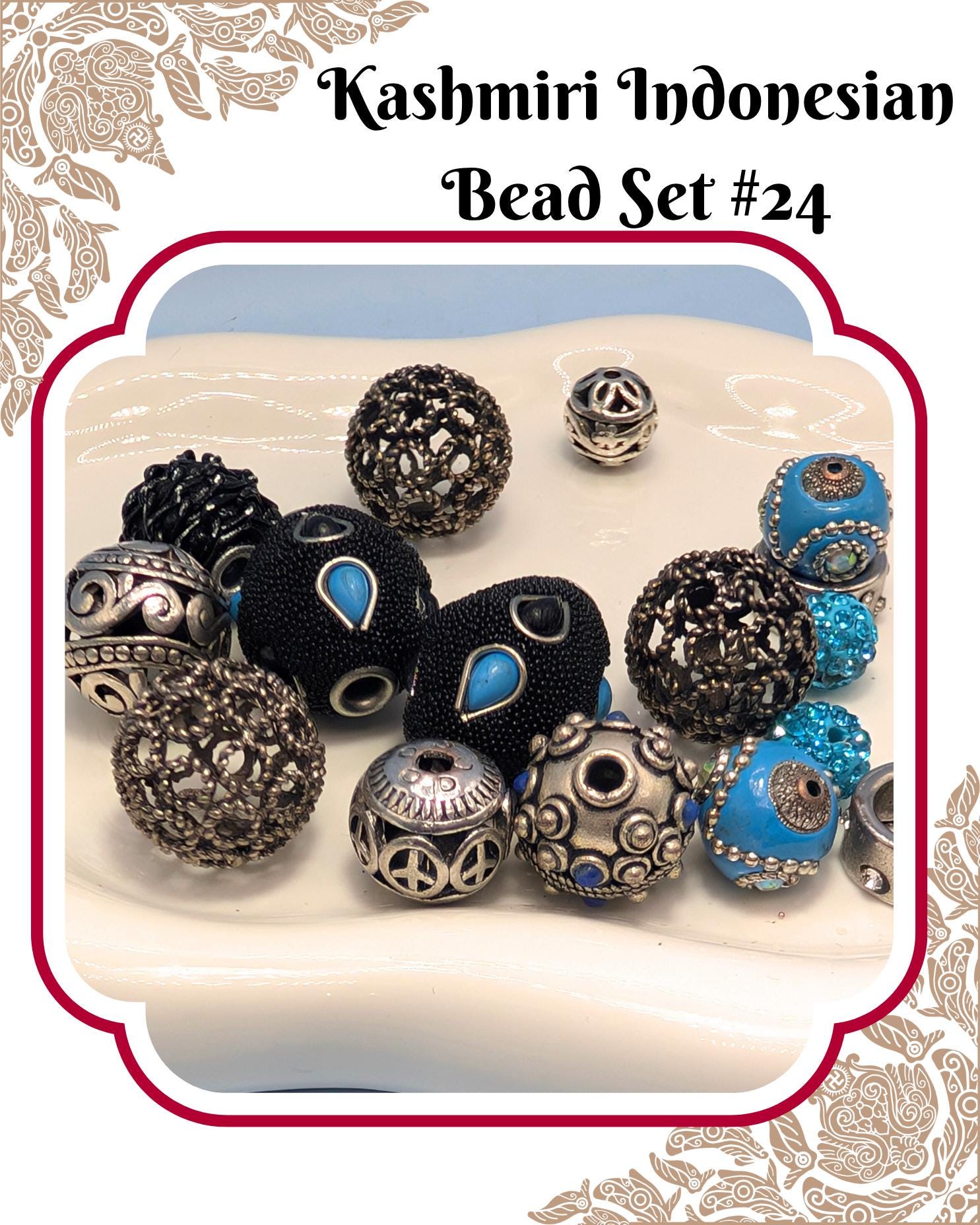 A collection of various beads, including black, blue, and silver beads, arranged on a white surface.