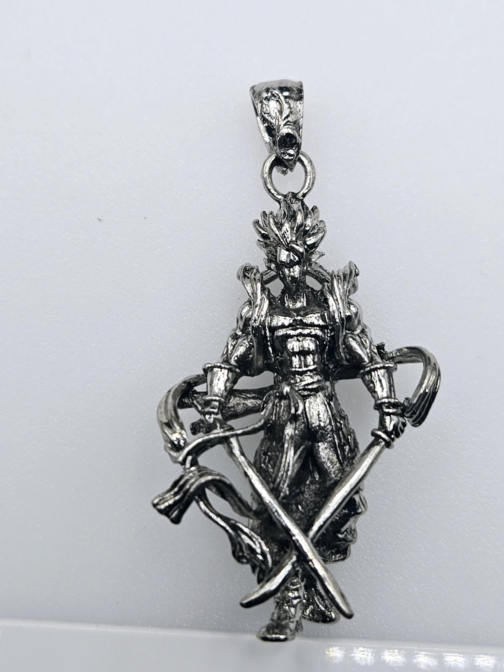 A silver-colored pendant in the shape of a sword, with intricate details and a decorative design.