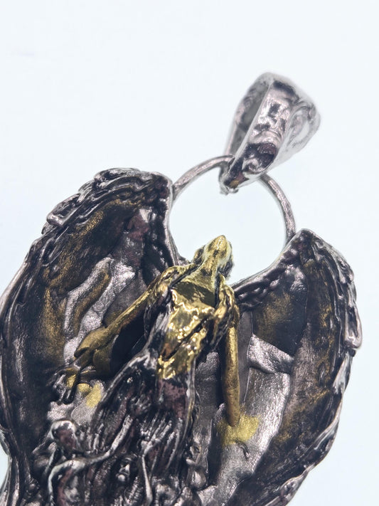 A close-up view of a pendant featuring a detailed metal sculpture of a bird, possibly an eagle, with intricate details and a shiny, metallic appearance.