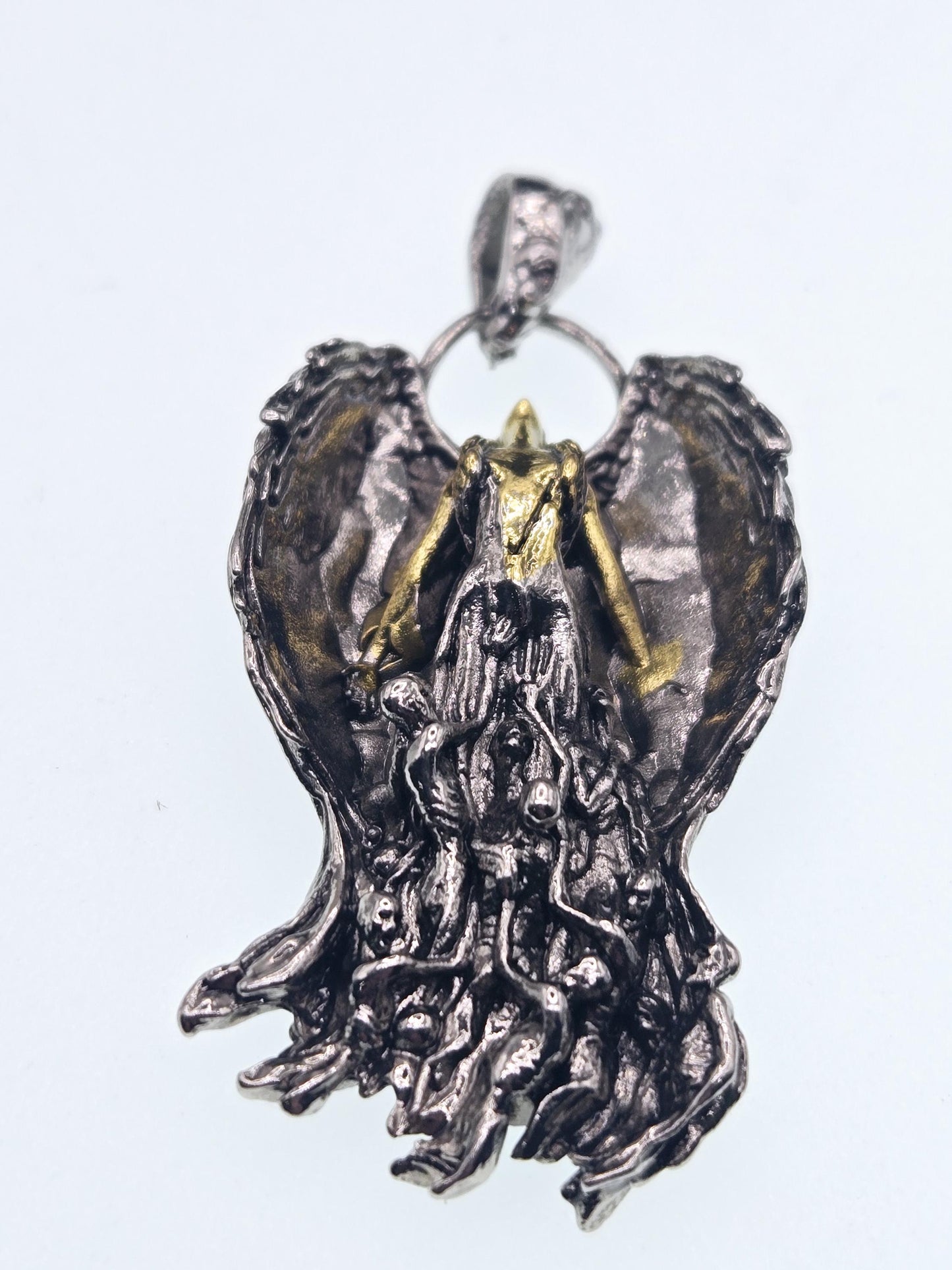 a pendant in the shape of a dragon or sea monster, with intricate details and a metallic finish.
