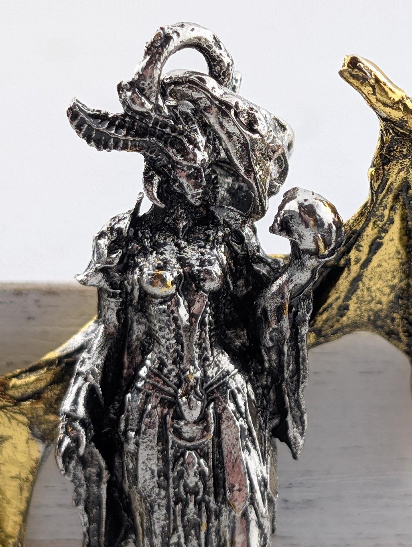 a detailed metal sculpture of a female figure with an ornate, intricate design.