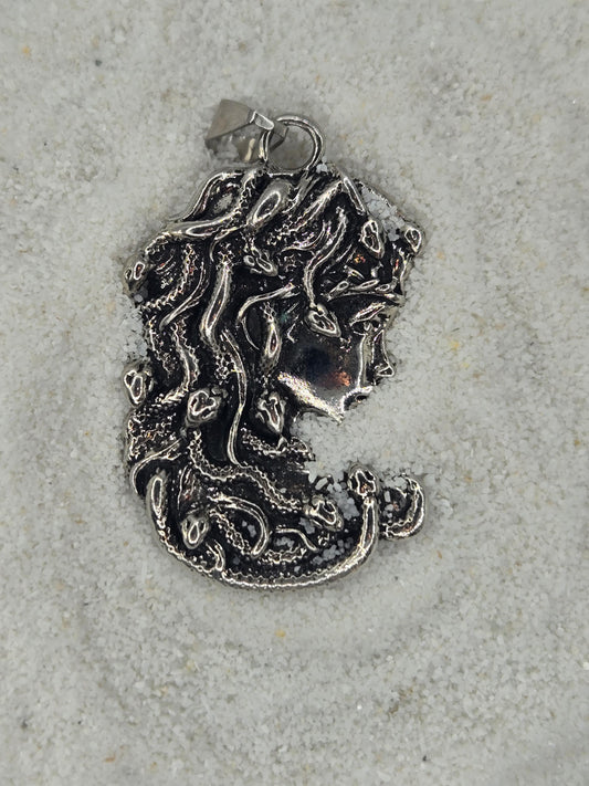 a silver-colored metal piece with an intricate, organic design, resembling a piece of jewelry or a decorative item.