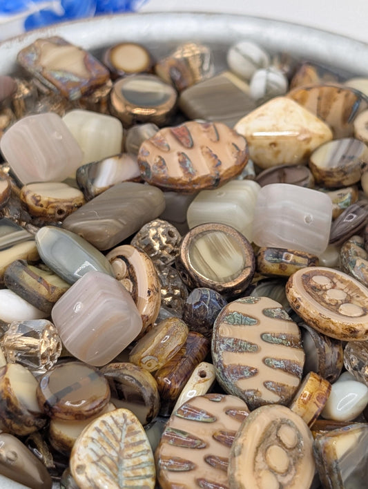a close-up view of a collection of various beads and stones, including glass beads and stones in different shapes, sizes, and colors.