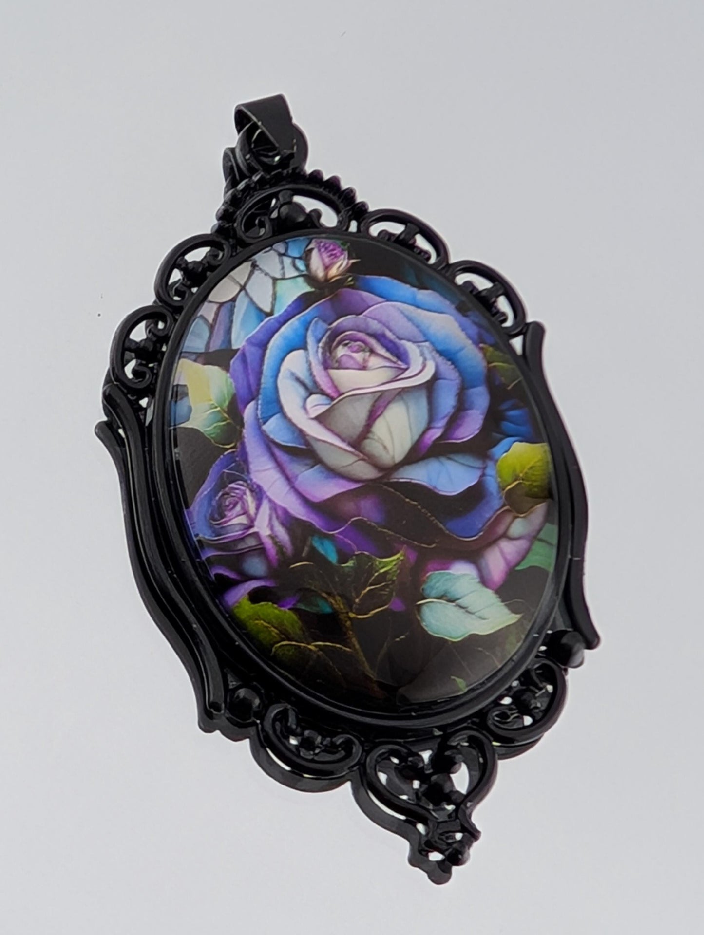 A pendant with a floral design featuring a large, colorful rose surrounded by various other flowers and leaves.