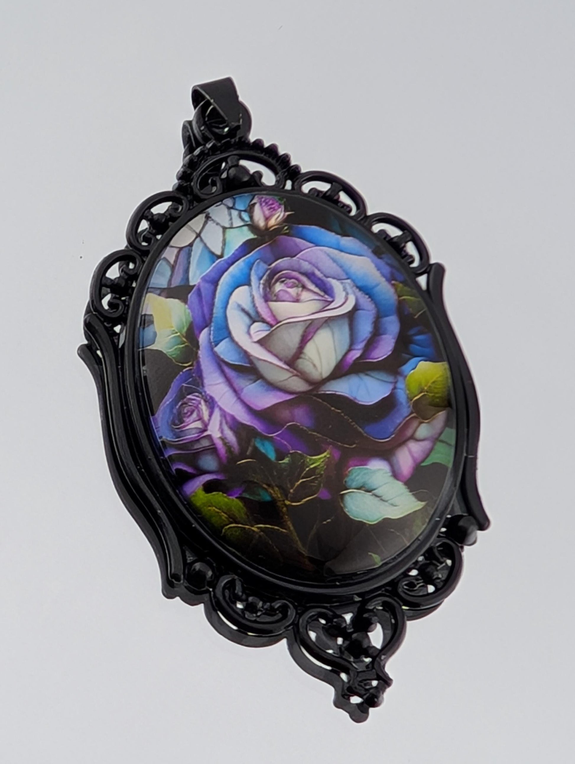 A pendant with a floral design featuring a large, colorful rose surrounded by various other flowers and leaves.