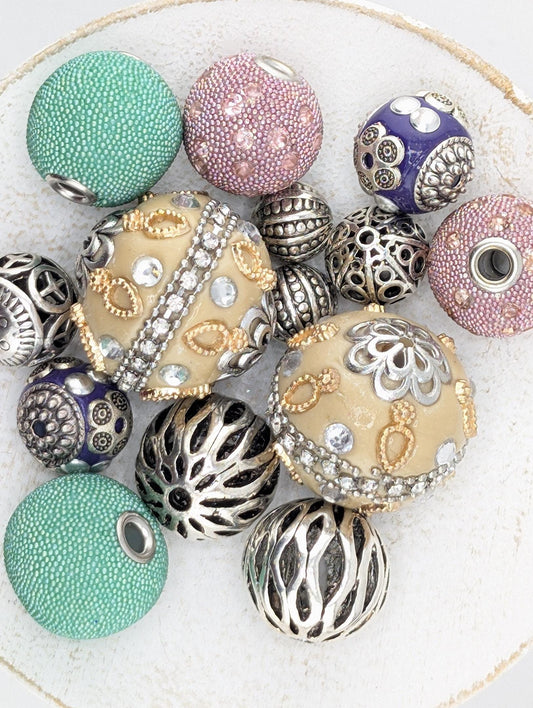 a collection of various beads and jewelry pieces, including some with intricate designs and patterns.