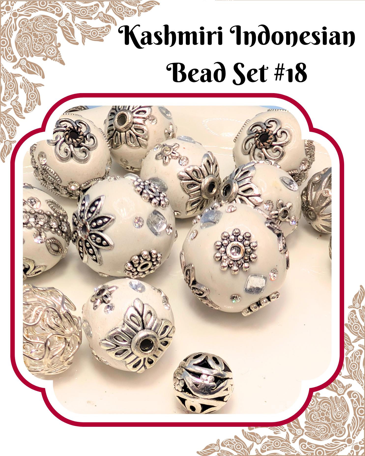 A collection of ornate, decorative beads in shades of white and silver, with intricate floral and leaf designs. The beads are arranged in a visually appealing manner, creating a sense of depth and texture.