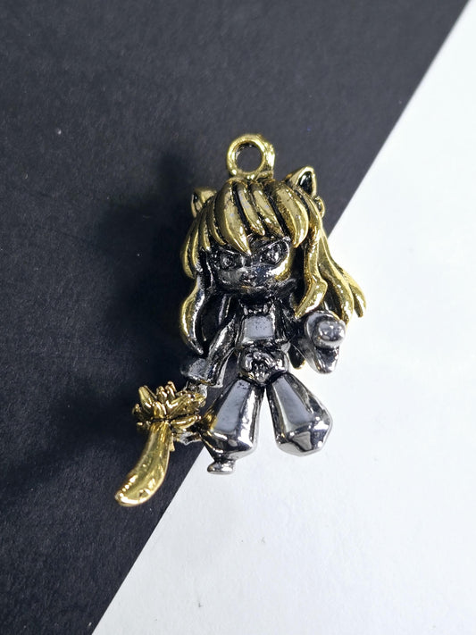 A decorative metal charm in the shape of a girl with a golden headband and a silver body, resting on a black surface.