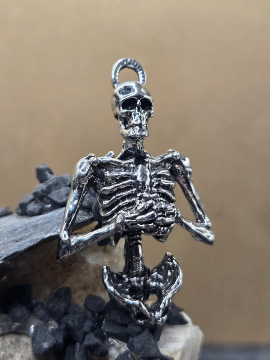 A silver-colored metal skeleton charm is shown in the image.