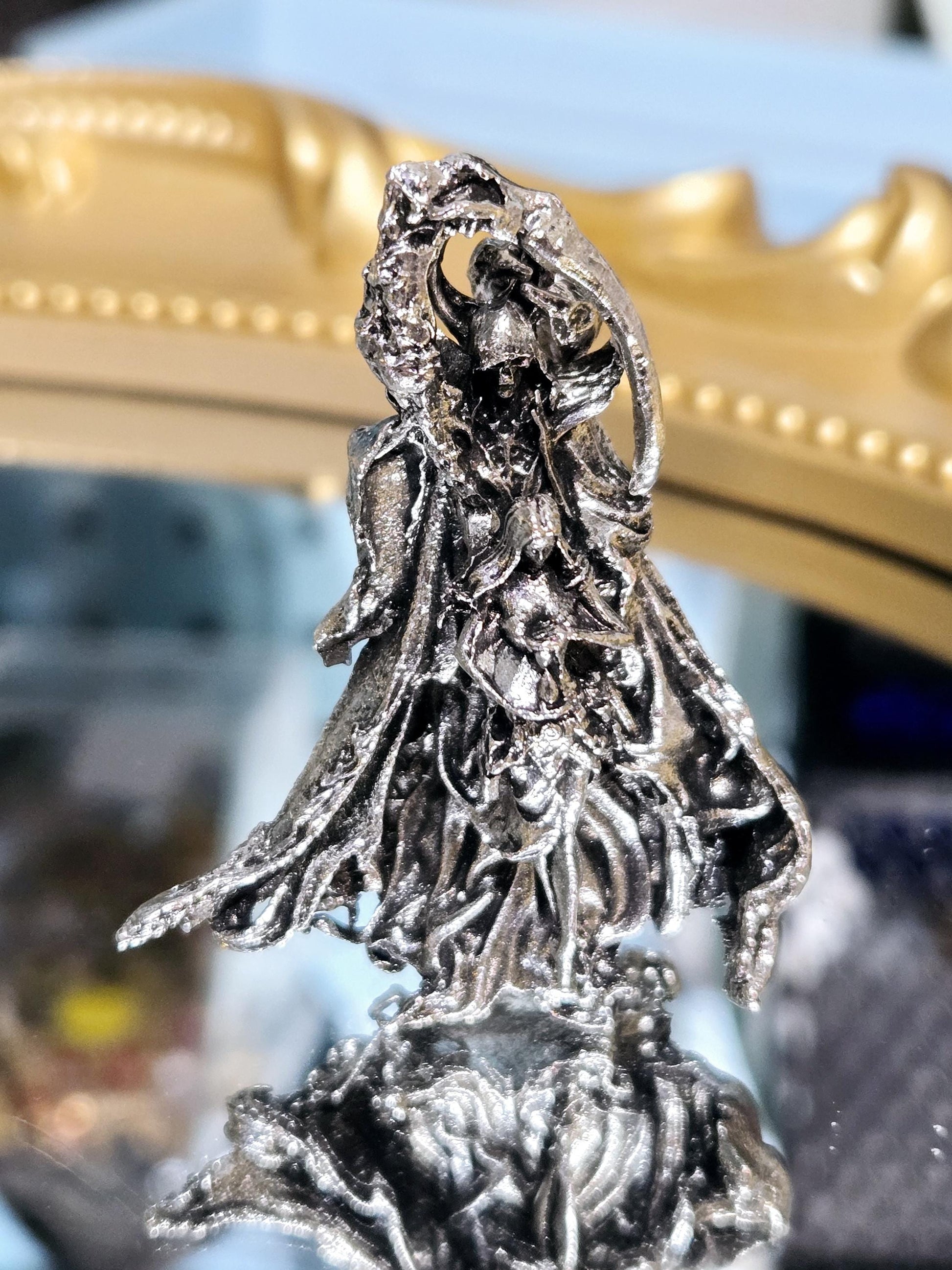 a close-up view of a metallic dragon sculpture, with intricate details and a shiny, metallic appearance.