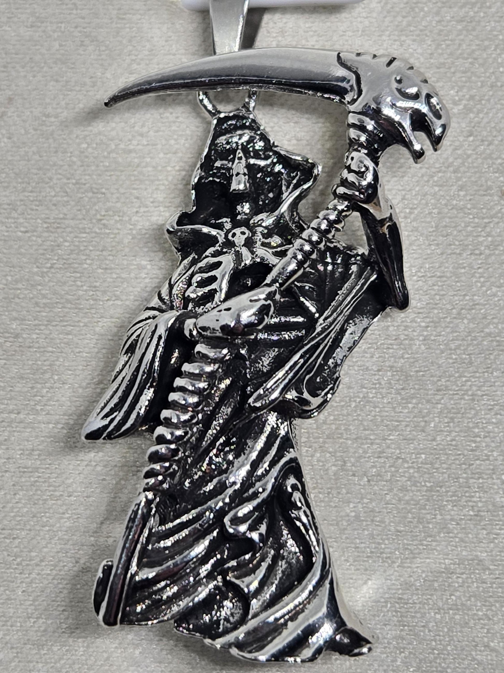 A silver brooch or pin featuring a detailed, intricate design of a skull and crossbones symbol.