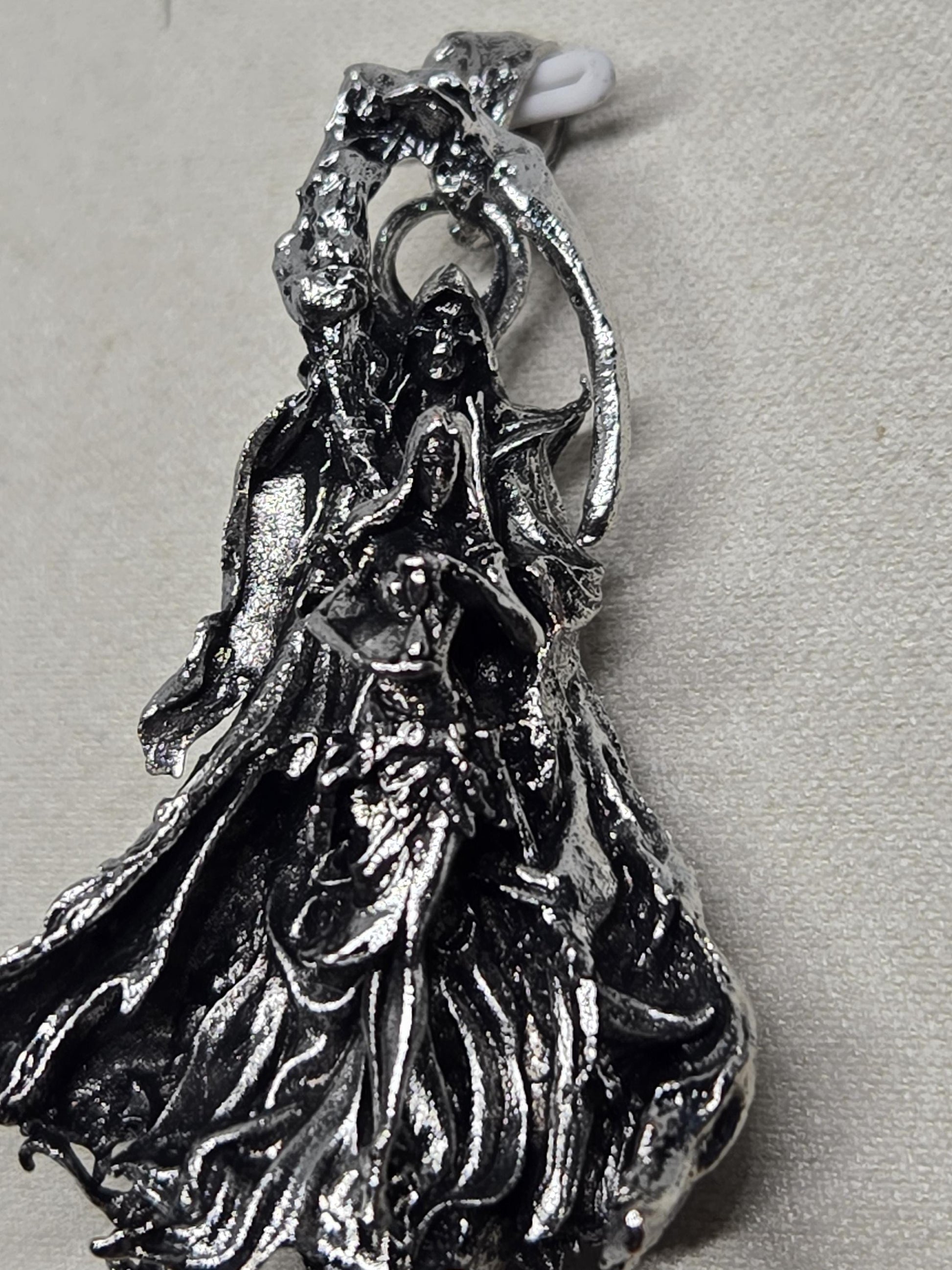 a close-up view of a metallic, sculptural object with a textured, organic appearance.
