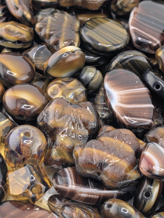 a close-up view of various colored beads and stones, including brown, black, and gold-toned pieces.