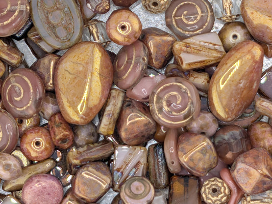 a variety of colorful beads and stones, including gold, brown, and pink hues, arranged in a visually appealing manner.